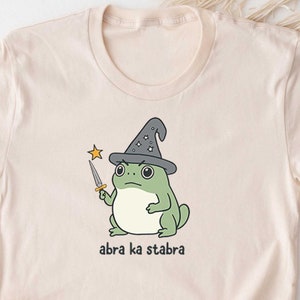 Camiseta divertida de mago rana. Bonita camiseta, camiseta, camisetas. Espada mágica de fantasía de rana. Videojuegos de rol, cartas, juegos de mesa. Abra Ka Stabra. Sapo