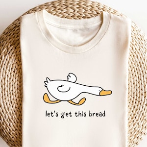 A funny duck shirt that says let's get this bread.
