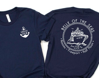 Op de afbeelding: Een marineblauw t-shirt met een wit anker en de tekst "Cruise Crew" op de voorkant. De achterkant van het shirt heeft een witte cirkel met de tekst "Belle of the Seas" en een schip in de cirkel. De tekst "Nassau, Freeport, Half Moon" staat onder de cirkel.