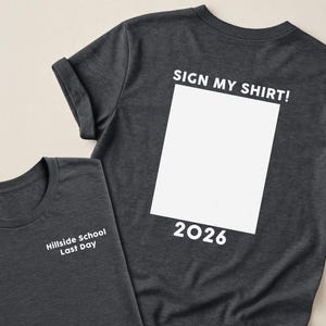 May include: Two dark gray t-shirts. One shirt has the text "Hillside School Last Day" on the front. The other shirt has the text "SIGN MY SHIRT!" above a white rectangle and the number "2026" below the rectangle.