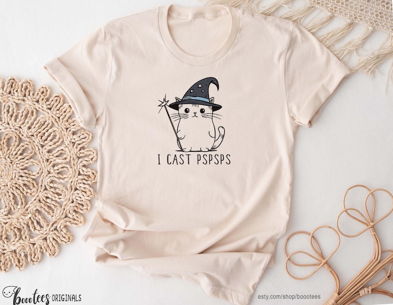 An illustration of a cat wearing a black wizard hat, holding a staff with the text I cast pspsps underneath