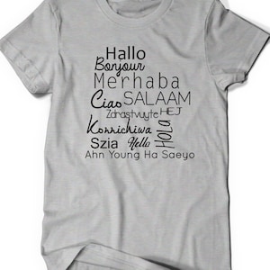 Puede incluir: Camiseta gris con texto negro que dice "Hallo Bonjour Merhaba Ciao Salaam Zdrastvuyte Hej Konnichiwa Szia Hello Hola Ahn Young Ha Saeyo"