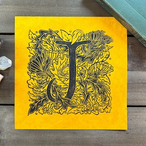 Lettre illustrée – J | Impression murale linogravure faite main | Papier Lokta orange | 9 x 9 po. | Décorations artistiques et artisanales, flore et filigrane