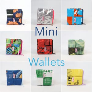 Könnte beinhalten: Eine Sammlung quadratischer Mini-Geldbörsen in verschiedenen Farben und Mustern. Die Geldbörsen bestehen aus recycelten Materialien und verfügen über Reißverschlüsse. Das Wort "Mini" steht in Blau über den Geldbörsen, und das Wort "Wallets" steht in Blau darunter.