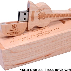 K&ouml;nnte beinhalten: Ein h&ouml;lzerner USB-Stick in Gitarrenform mit einer Kapazit&auml;t von 16 GB und einer USB 3.0-Schnittstelle. Der Stick wird in einer Holzkiste mit dem eingravierten Namen "Franco Mantegani Fotografo" geliefert.