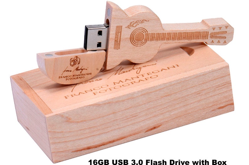 K&ouml;nnte beinhalten: Ein h&ouml;lzerner USB-Stick in Gitarrenform mit einer Kapazit&auml;t von 16 GB und einer USB 3.0-Schnittstelle. Der Stick wird in einer Holzkiste mit dem eingravierten Namen "Franco Mantegani Fotografo" geliefert.