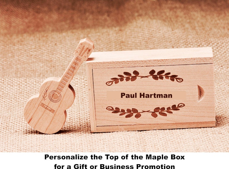 K&ouml;nnte beinhalten: Eine Holzkiste mit einem gitarrenf&ouml;rmigen Deckel. Die Oberseite der Kiste ist mit dem Namen "Paul Hartman" und einem dekorativen Blumendesign personalisiert. Die Kiste ist ideal f&uuml;r ein Geschenk oder eine Gesch&auml;ftswerbung.