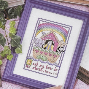 May include: A framed cross-stitch design featuring a rainbow, a boat, and the text "I set my bow in the cloud. Gen. 9:13".