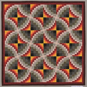 May include: A quilt with a geometric pattern of squares and triangles in shades of red, orange, yellow, black, and gray.