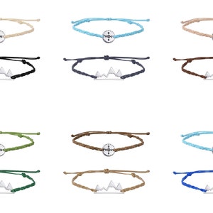 May include: Set of 12 bracelets with different colored cords and two different charms. One charm is a compass and the other is a mountain range.