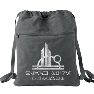 May include: A gray drawstring backpack with a white graphic of a city skyline and the text "ENKIO NU17V  DIJVDOVN".