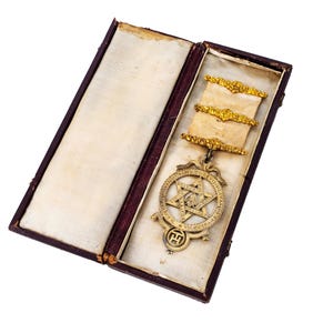 May include: A white ceramic mug with a black handle and the text "But First, Coffee" in a black, handwritten-style font. The mug is on a white surface.