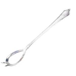 May include: A long, silver-colored cocktail spoon with a decorative handle and a looped end with two small tines. The spoon is designed for stirring drinks and has an elegant, vintage appearance.