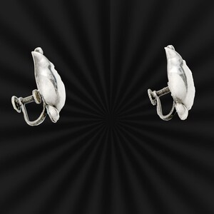 May include: A pair of silver clip-on earrings shaped like a leaf.