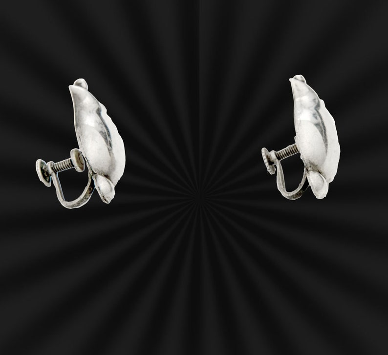 May include: A pair of silver clip-on earrings shaped like a leaf.