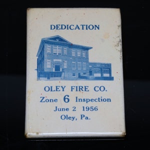 May include: A white card with blue text and a blue and white image of a building. The text reads "DEDICATION", "OLEY FIRE CO.", "Zone 6 Inspection", "June 2 1956", and "Oley, Pa."