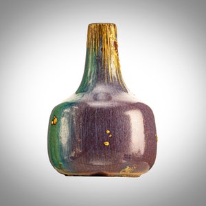 May include: A small, round, purple and green ceramic vase with gold accents. The vase has a narrow neck and a wide base.