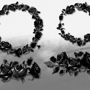 May include: Black and white floral wreath and floral arrangements. The image features two circular wreaths and two floral arrangements. The flowers are roses and are in various stages of bloom. The background is a gradient of gray and white.