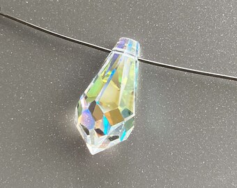 May include: A clear iridescent teardrop-shaped crystal bead with a hole at the top, hanging from a thin silver wire.