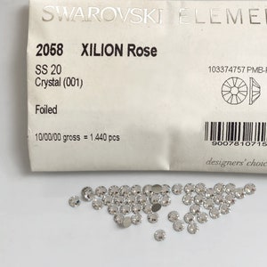May include: A pack of 1,440 silver Xilion Rose crystals, size 20, from Swarovski Elements. The pack includes the product code 2058, the crystal code 001, and the text "designers' choice since 1895".