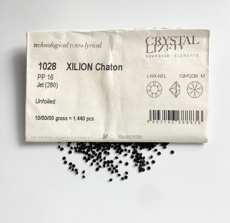 Puede incluir: Un paquete de 1.440 cristales negros Xilion Chaton de Swarovski. El paquete est&aacute; etiquetado con el n&uacute;mero de producto 1028, PP 16, Jet (280), Unfoiled y 10/00/00 gross = 1.440 pcs. El paquete tambi&eacute;n incluye un c&oacute;digo de barras y el logotipo de Swarovski.