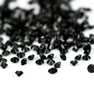 Puede incluir: Una dispersi&oacute;n de diamantes de imitaci&oacute;n negros en forma de diamante sobre un fondo blanco.