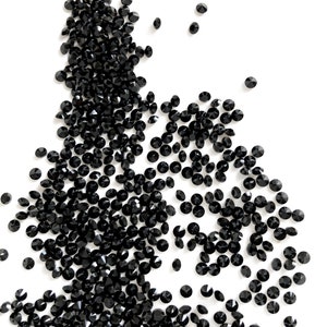 Puede incluir: Una dispersi&oacute;n de cristales negros en forma de diamante sobre un fondo blanco.