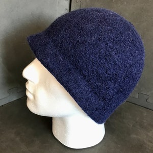 Può includere: Un berretto di lana blu scuro con una vestibilità morbida. Il berretto è realizzato in un materiale morbido e soffice.