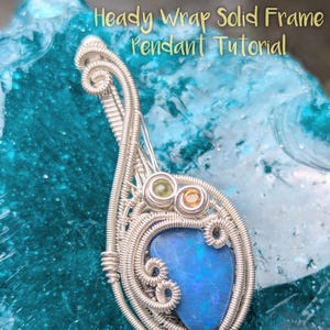 Peut inclure: Pendentif artisanal en fil d'argent avec une pierre d'opale bleue au centre. Le pendentif présente un enroulement de fil complexe et de petites pierres précieuses colorées. Le texte sur l'image indique "Heady Wrap Solid Frame Pendant Tutorial" et "From Tobe Rose."