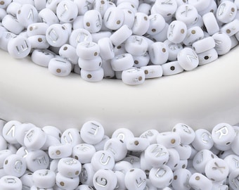 May include: White round beads with silver letter imprints, scattered across a white surface. The beads are uniform in size and shape, with a small hole for stringing. Ideal for jewelry making and crafts.
