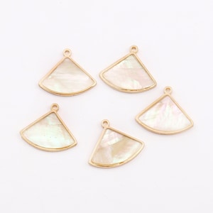 May include: Five gold-toned metal fan-shaped charms with white mother-of-pearl inserts. The charms have a loop at the top for attaching to jewellery or other crafts.