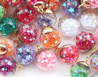 May include: Assortment of small glass ornaments filled with colorful star-shaped glitter. Each ornament has a gold-colored metal loop for hanging.