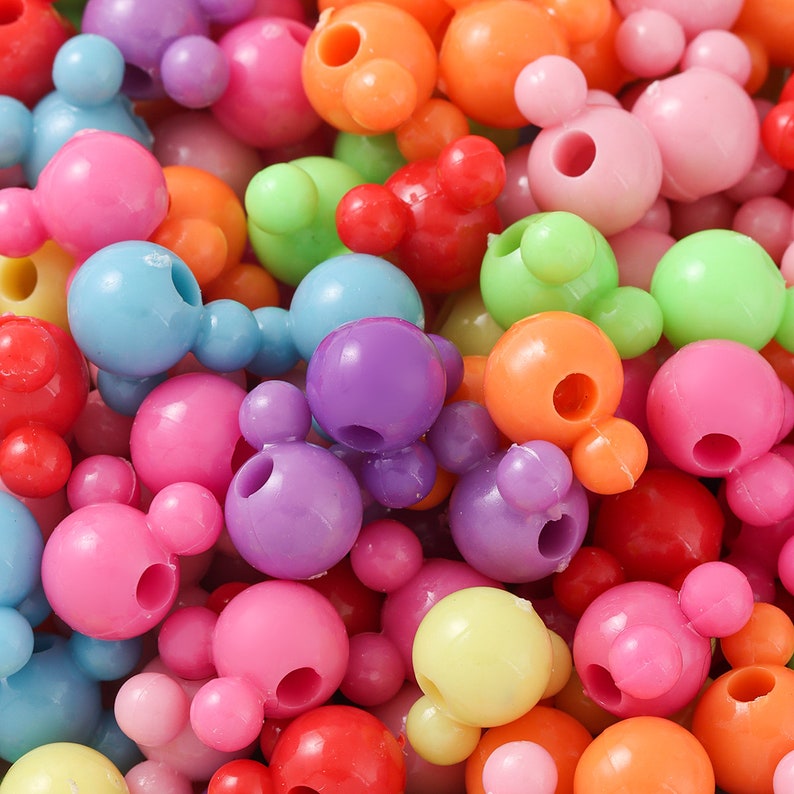 May include: A large assortment of colorful plastic beads in various shapes, including round and Mickey Mouse-shaped beads. The beads are perfect for crafting and jewelry making.