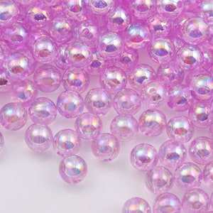 May include: A large quantity of iridescent purple plastic beads. The beads are round and have a smooth, shiny finish.