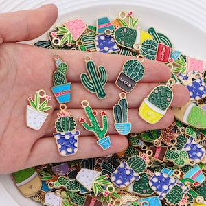 Può includere: Un vasto assortimento di ciondoli in metallo colorati a forma di cactus e piante grasse. I ciondoli sono a forma di piante in vaso con diversi colori e design. I ciondoli sono perfetti per aggiungere un tocco di fantasia a gioielli, borse o portachiavi.