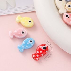 Pode incluir: Conjunto de cinco pequenas estatuetas de peixe de cer&acirc;mica com bolinhas brancas e olhos pretos. Os peixes s&atilde;o de v&aacute;rias cores: amarelo, rosa, azul e vermelho. Os peixes medem aproximadamente 3,1 cm de comprimento.