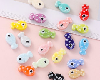 May include: A collection of colorful fish-shaped beads with white polka dots and a single black eye. The beads are made of plastic and are perfect for crafting jewelry or other projects.