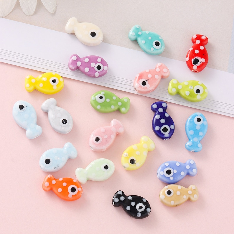 Pode incluir: Uma cole&ccedil;&atilde;o de contas coloridas em forma de peixe com bolinhas brancas e um &uacute;nico olho preto. As contas s&atilde;o de pl&aacute;stico e s&atilde;o perfeitas para fazer joias ou outros projetos.