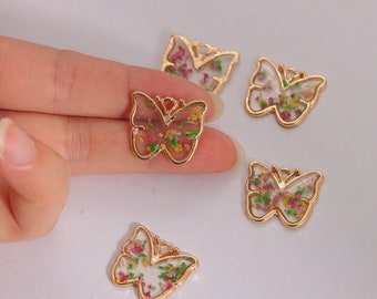 May include: Five gold-tone butterfly charms with a floral design inside. The butterflies are about 1 inch in size.