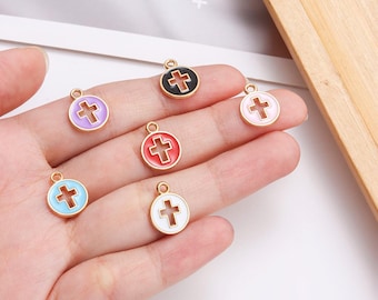May include: A collection of colorful enamel cross charms. Each charm features a gold-tone border and a cross design in various colors, including purple, black, red, pink, blue, and white. These small pendants are suitable for jewelry making.