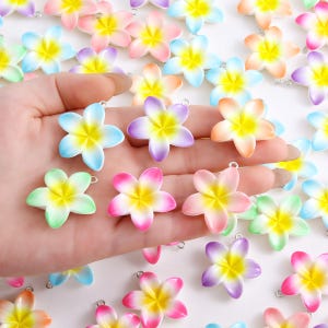 May include: A collection of colorful, five-petal flower charms in various shades of pink, purple, blue, green, and orange with yellow centers. Each charm has a small silver loop for attaching to jewelry or other crafts.