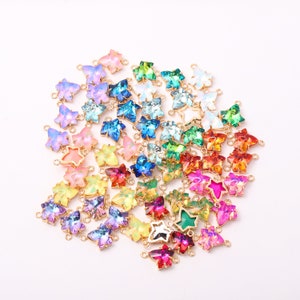 May include: A collection of colorful leaf-shaped charms with gold-colored metal frames. The charms feature a variety of iridescent colors, including pink, blue, green, yellow, and red. These decorative charms are ideal for jewelry making and crafting projects.