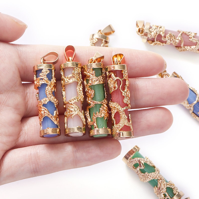 May include: Five gold dragon pendants with different colored stones. The stones are blue, pink, green, and red. The pendants are all in the shape of a cylinder with a dragon design.