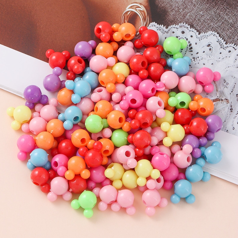 May include: A large pile of colorful plastic beads with a Mickey Mouse head design. The beads are in various colors, including red, orange, yellow, green, blue, purple, and pink.