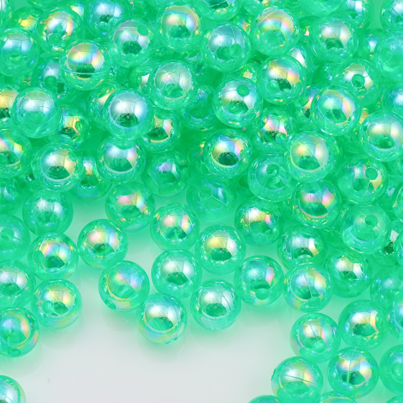 May include: A large pile of iridescent green plastic beads. The beads are round and have a smooth, shiny finish.