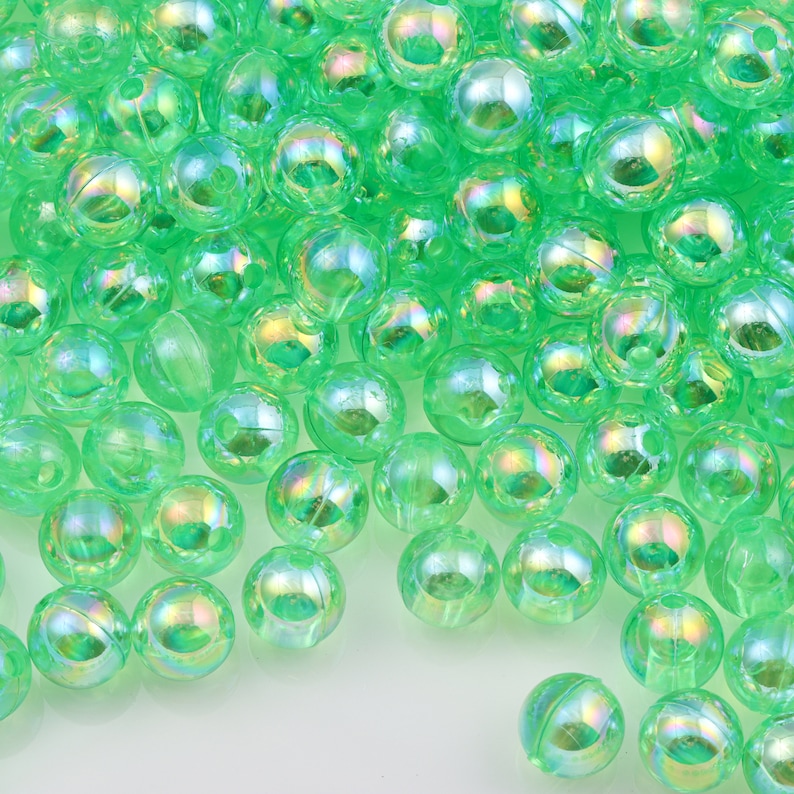 May include: A large group of iridescent green plastic beads. The beads are round and have a smooth, shiny finish.