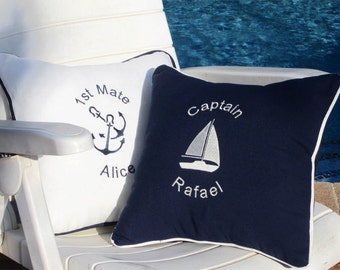 May include: Two square throw cushions with nautical themes. One white cushion features a dark blue anchor, the text 1st Mate, and the name Alice. The other navy blue cushion features a white sailboat, the text Captain, and the name Rafael.