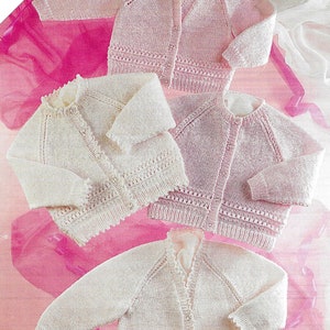 May include: Four knitted baby cardigans in pink and white. The cardigans are laid out on a pink and white background. The text "Includes Premature Sizes" is visible in the top left corner of the image.