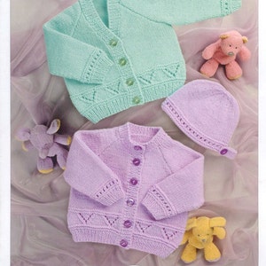 May include: Two knitted baby cardigans, one in light green and one in light purple, with a matching light purple knitted hat. Both cardigans feature a button-up front and a delicate lace pattern.