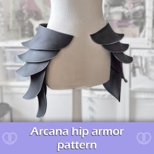 May include: A set of dark gray hip armor pieces displayed on a mannequin torso. The armor features a layered, scale-like design with multiple curved plates extending downward on both sides. The text Arcana hip armor pattern is visible below.